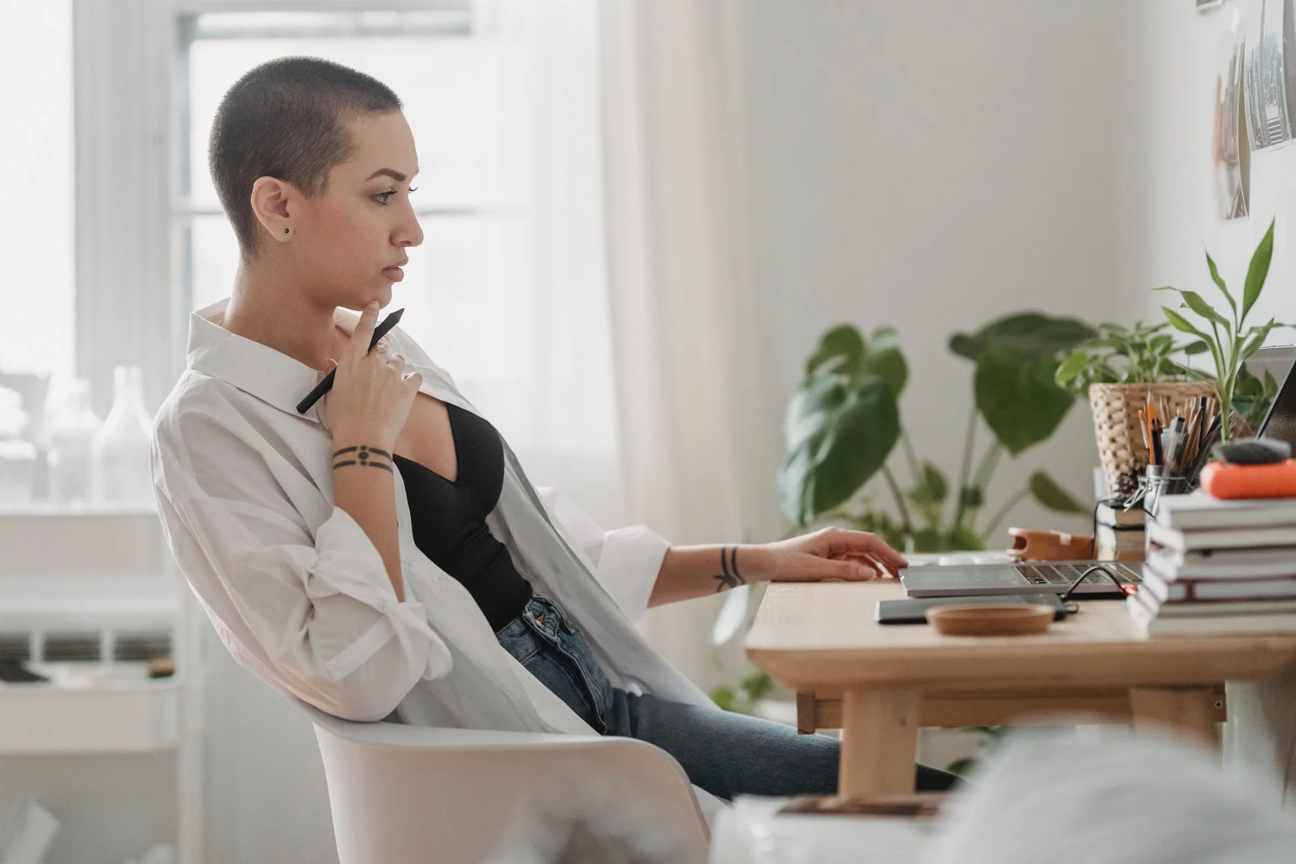 pensive woman working on laptop at desk